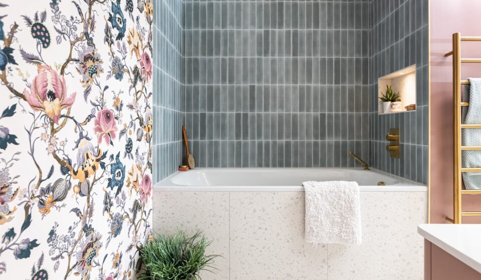 Girls en-suite with floral wallpaper matching the headboard, pink vanity unit and gold hardware