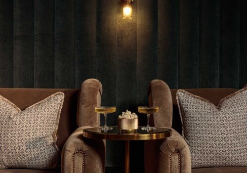 Dark tones velvet cinema room with luxurious armchairs and cocktail table