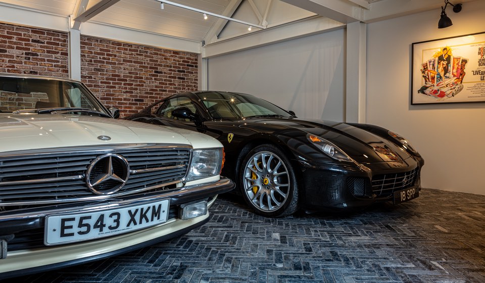 Garage with exposed brick wall, spotlights and classic cars