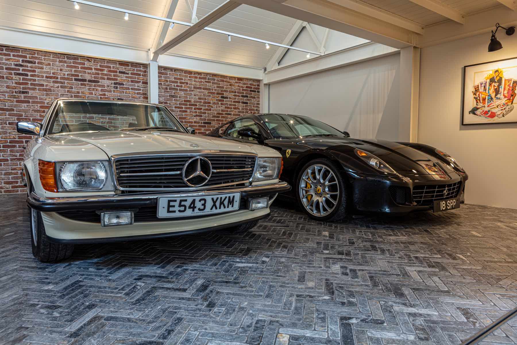 Garage with exposed brick wall, spotlights and classic cars