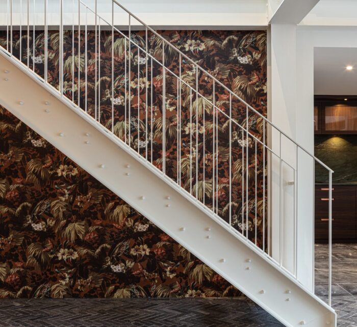 White metal staircase against backdrop of decorative wallpaper
