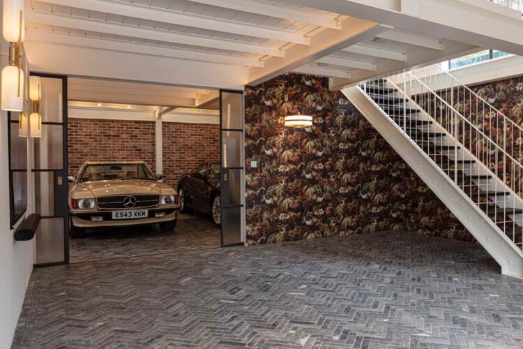 Entrance to garage with classic cars and herringbone stone flooring