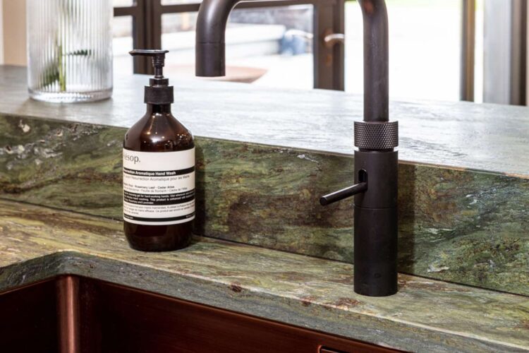 Green marble sink surround with black tap