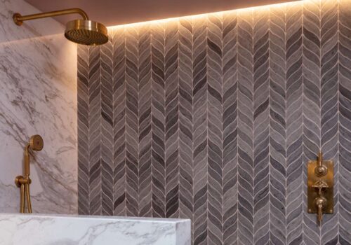 Bathroom with brass fittings, marble walls and decorative tiling