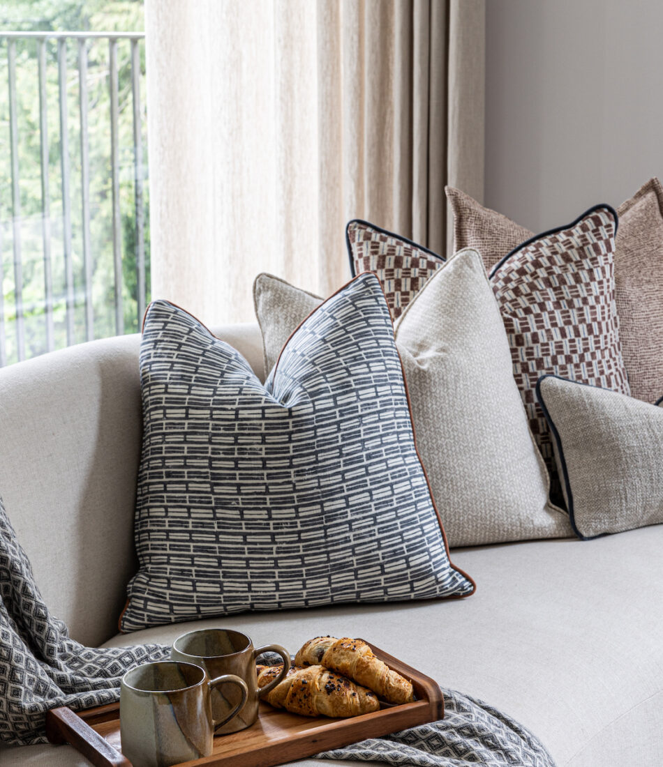 urban contemporary bespoke soft furnishings warm neutral cushion scheme for a bespoke upholstered curved sofa