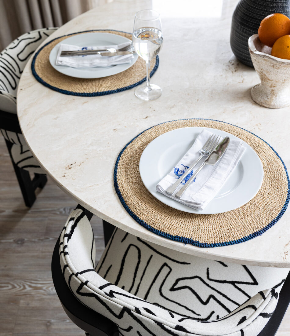 urban contemporary neutral apartment dining table setting geometric black and white chairs with travertine stone octagonal table