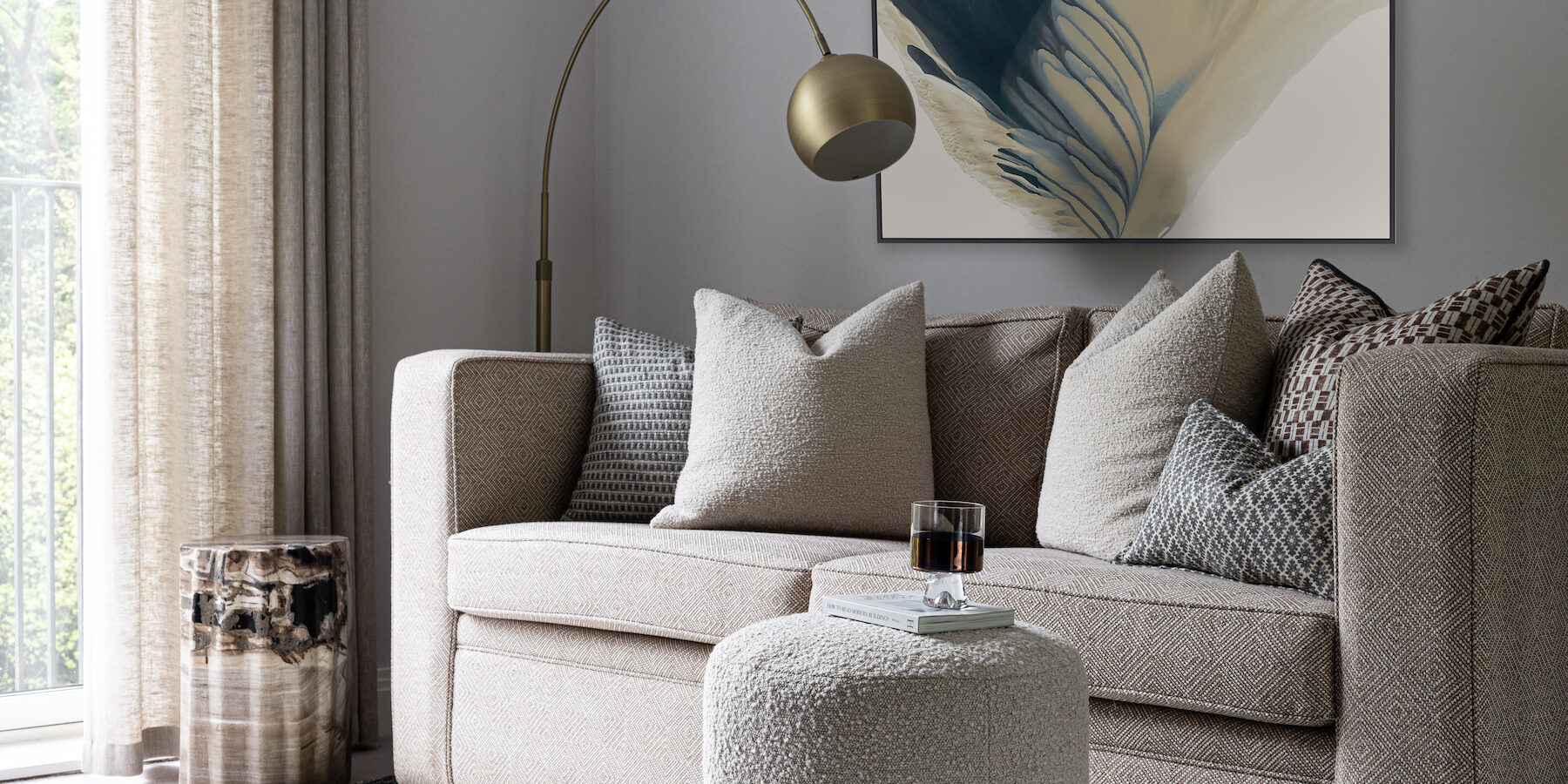 urban contemporary bespoke upholstered sofa bed with bespoke soft furnishings, footstools and petrified wood plinth