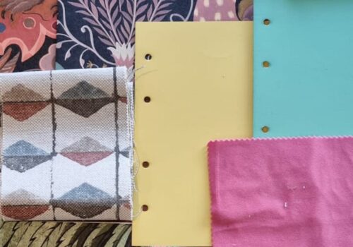 A collection of various textured swatches and colored papers is spread out. Patterns include floral, geometric, and abstract designs, arranged against a neutral background.
