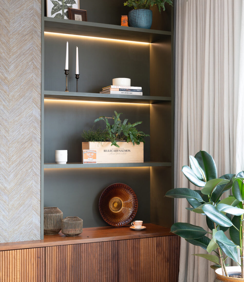 Contemporary Snug Shelving Designed with Bespoke Joinery by Pfeiffer Design. Warm wood joinery with dark green paint in recess and textured wallpaper with warm LED lighting design