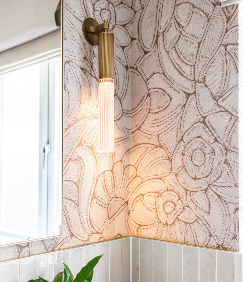 Art Deco Inspired Guest Bathroom/ Downstairs WC designed by Pfeiffer Design. Textured wallpaper in pale pink with half height tiling below, deep burgundy vanity unit with gold accent handles, warm wall lighting in a guest downstairs bathroom WC
