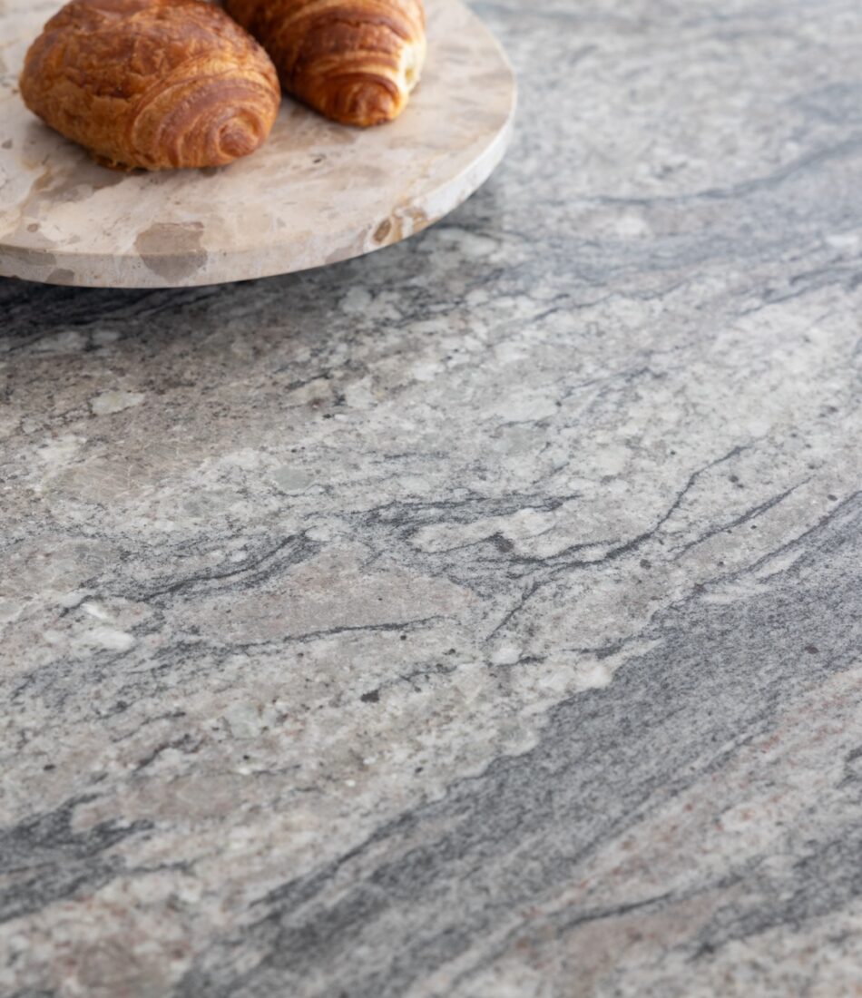 Art Deco Inspired Bespoke Kitchen made by our bespoke joiners, designed by Pfeiffer Design. Bespoke joinery, stone island work surface close up with breakfast pastries on a marble turntable platter