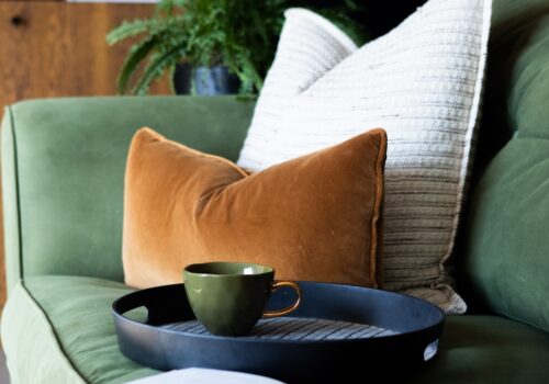 mid century modern beach house in East Sussex bespoke upholstered sofa in soft green velvet with bespoke scatter cushion scheme