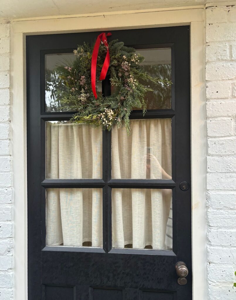 Festive wreath hanging on a brown door