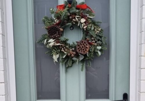 Festive wreath hanging on a blue door
