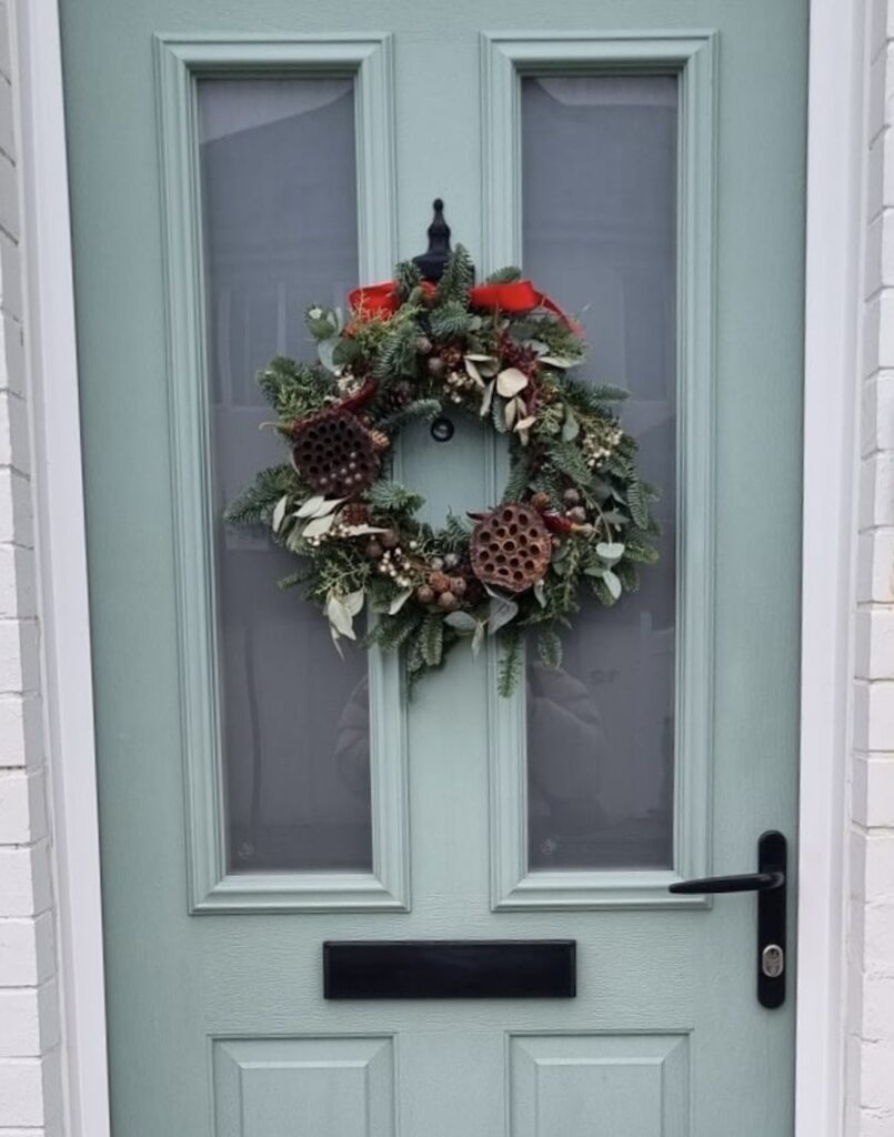 Festive wreath hanging on a blue door