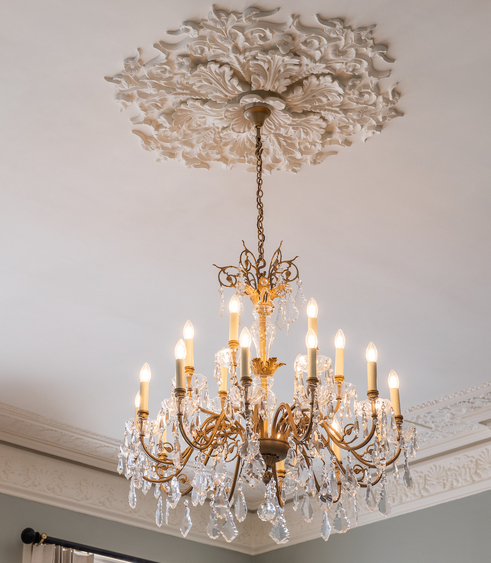 Close up image of traditional ceiling rose and original glass chandelier