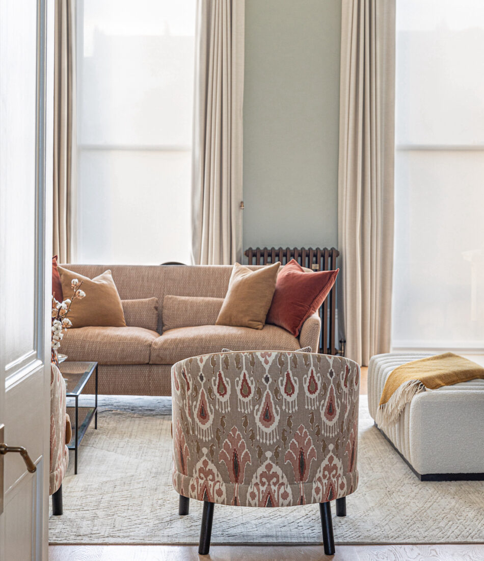 Regency Townhouse Lounge Living Room Interior Design with focus on upholstered furniture arm chair with red, beige, warm patterns and yellow cushions