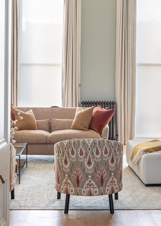 Regency Townhouse Lounge Living Room Interior Design with focus on upholstered furniture arm chair with red, beige, warm patterns and yellow cushions