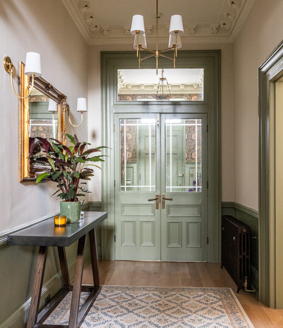 View of front door and Entrance Hall with high ceilings, regency townhouse, large rug and ceiling pendant
