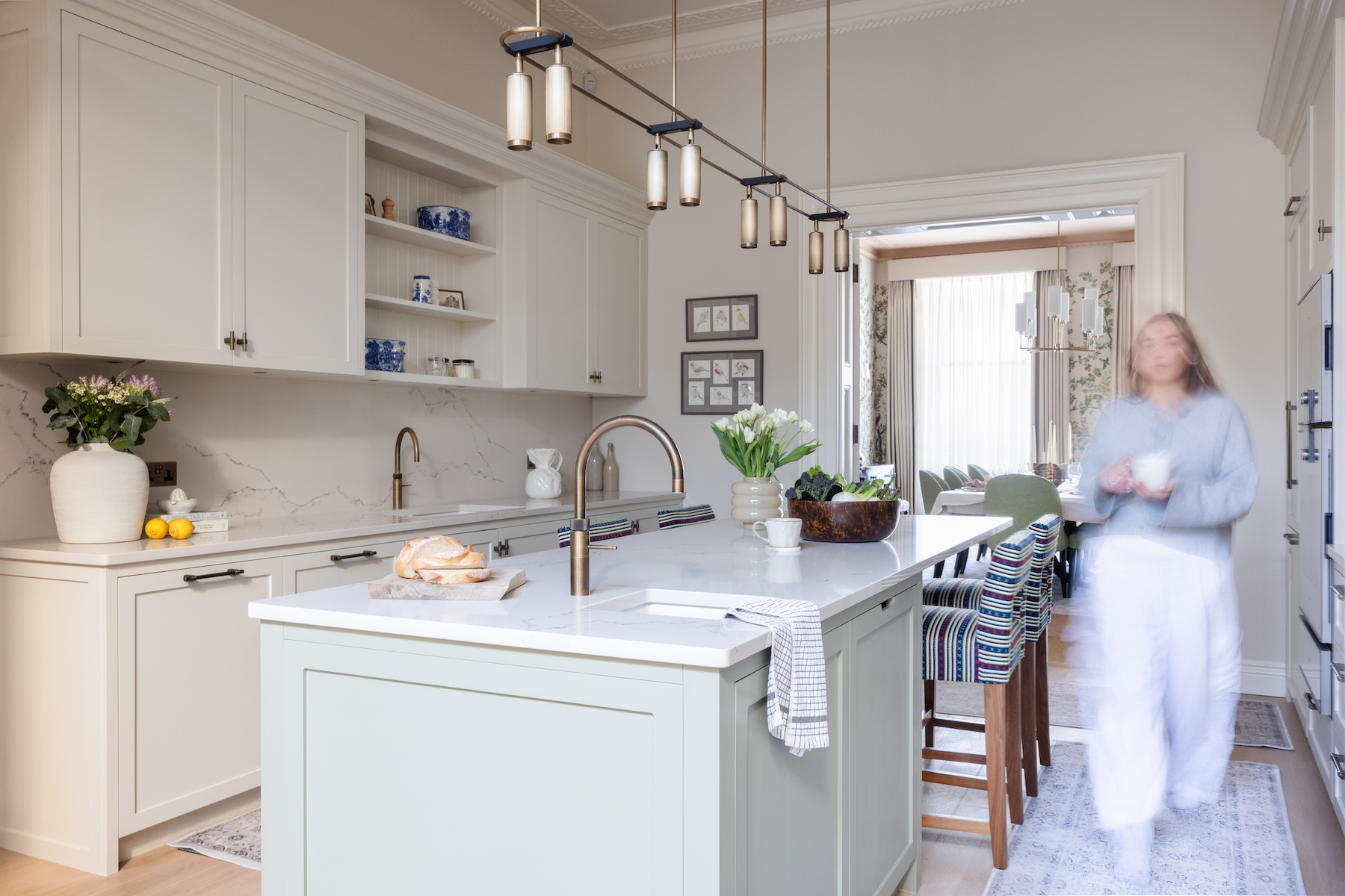 Traditional contemporary kitchen with neutral cabinets and pale green/grey island - brass/bronze hardware