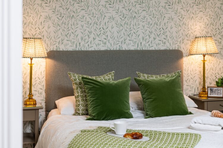 Guest Bedroom Interior Design - green cushions and layered patterns with leafy wallpaper design