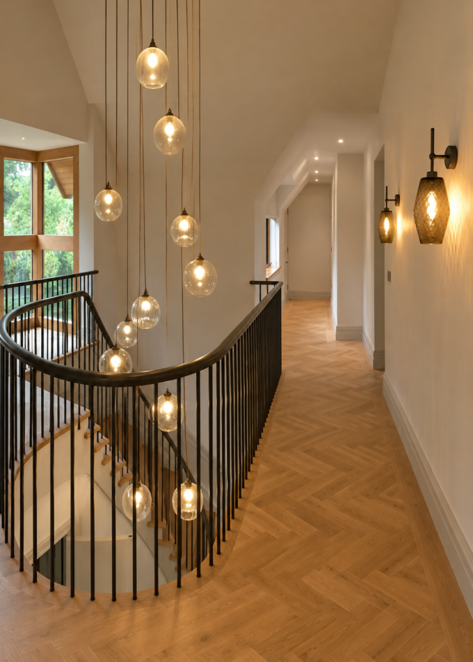 Elegant staircase with glass pendant lighting and wooden flooring.