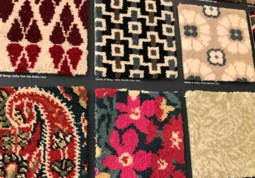 A variety of colorful patterned rug samples display intricate designs, arranged in a grid on a dark background. Each square showcases unique motifs and textures, indicating potential interior decor options.