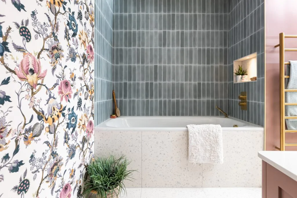 Girls en-suite with floral wallpaper matching the headboard, pink vanity unit and gold hardware