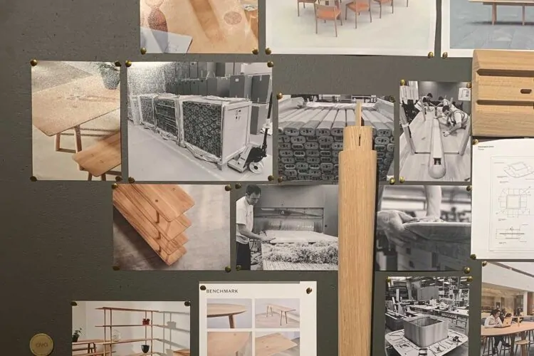 A wooden leg structure is vertically positioned among various images of furniture design pinned to a gray wall, showcasing tables, storage, and manufacturing processes in a creative workspace.