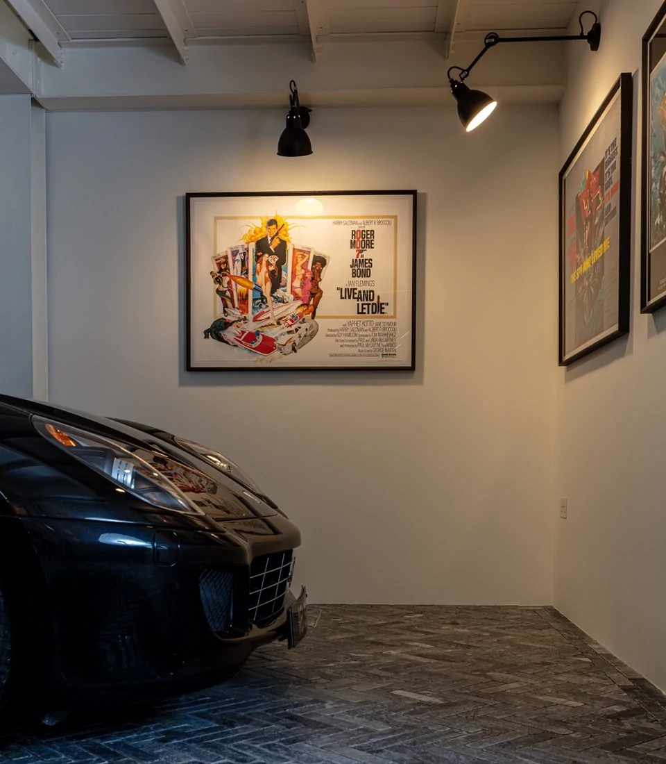Garage with exposed brick wall, spotlights and classic cars