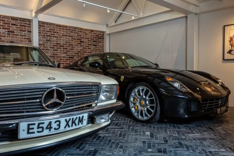 Garage with exposed brick wall, spotlights and classic cars