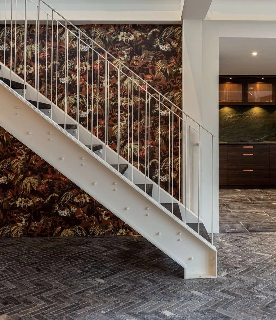 White metal staircase against backdrop of decorative wallpaper