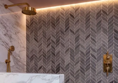 Bathroom with brass fittings, marble walls and decorative tiling