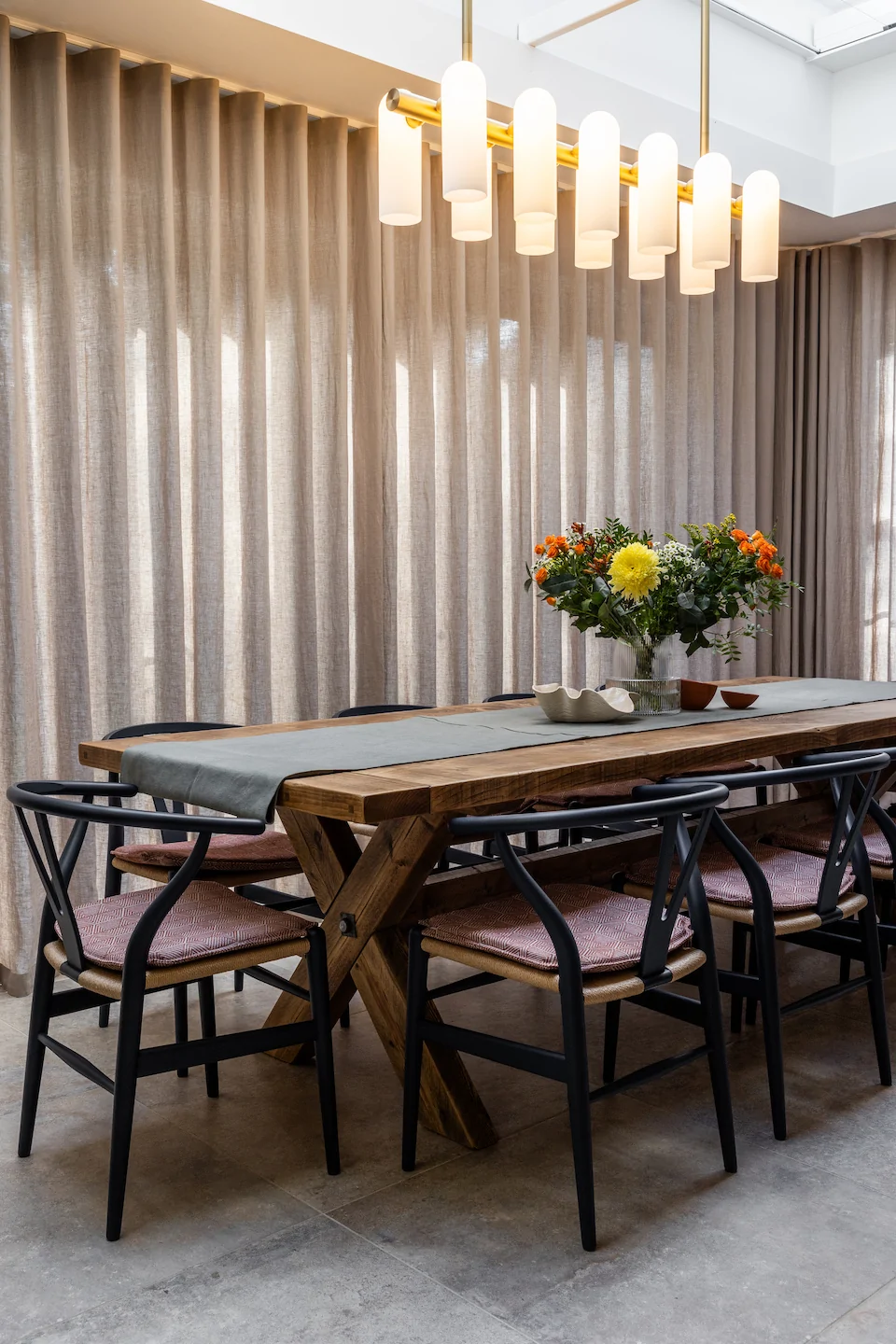 Family Dining Table with wave headed bespoke curtains, reclaimed timber dining table, and wishbone dining chairs with bespoke washable cushion pads.