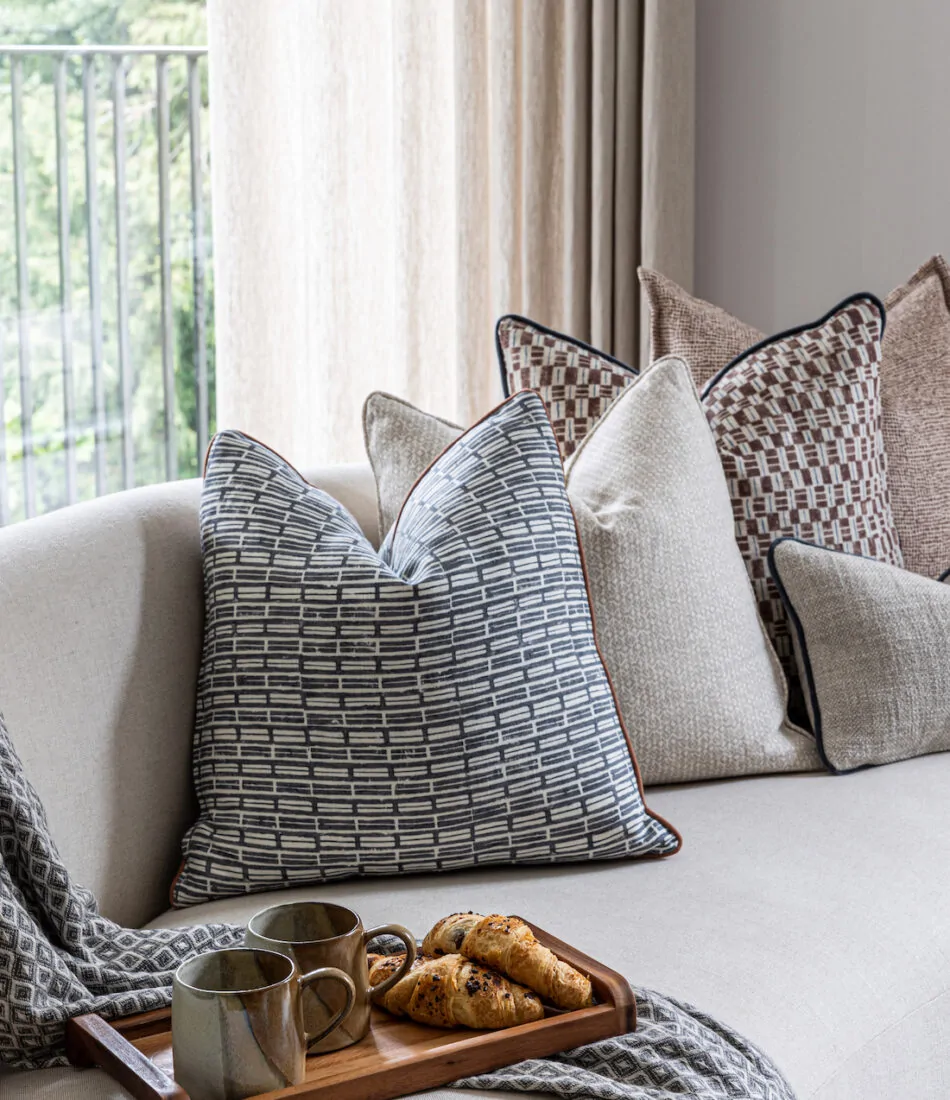 urban contemporary bespoke soft furnishings warm neutral cushion scheme for a bespoke upholstered curved sofa