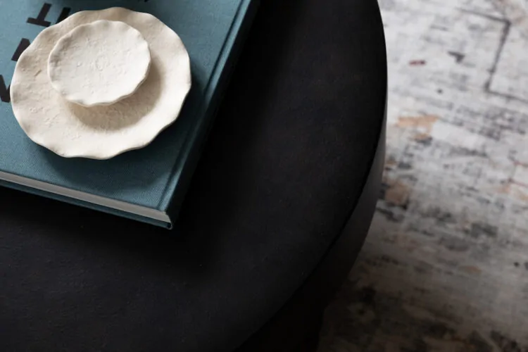 urban contemporary living room table setting with contemporary black circular table with books and accessories on the table
