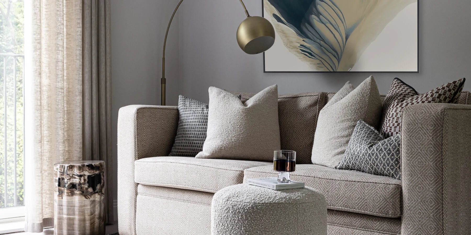 urban contemporary bespoke upholstered sofa bed with bespoke soft furnishings, footstools and petrified wood plinth