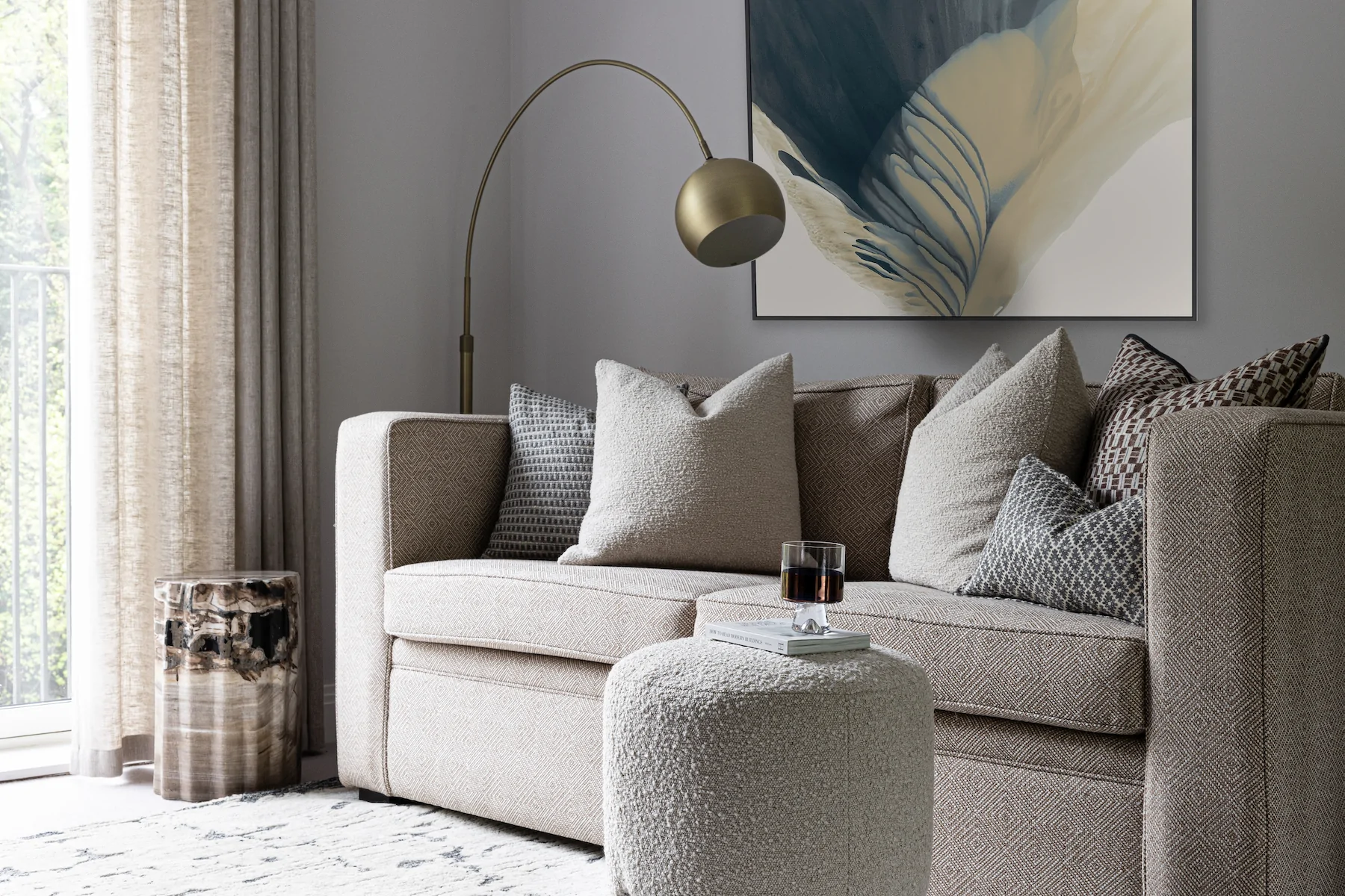 urban contemporary bespoke upholstered sofa bed with bespoke soft furnishings, footstools and petrified wood plinth