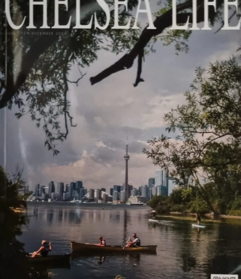 A magazine cover titled "CHELSEA LIFE" features a serene lake scene where people are canoeing, with a city skyline and the CN Tower visible in the background, surrounded by greenery.