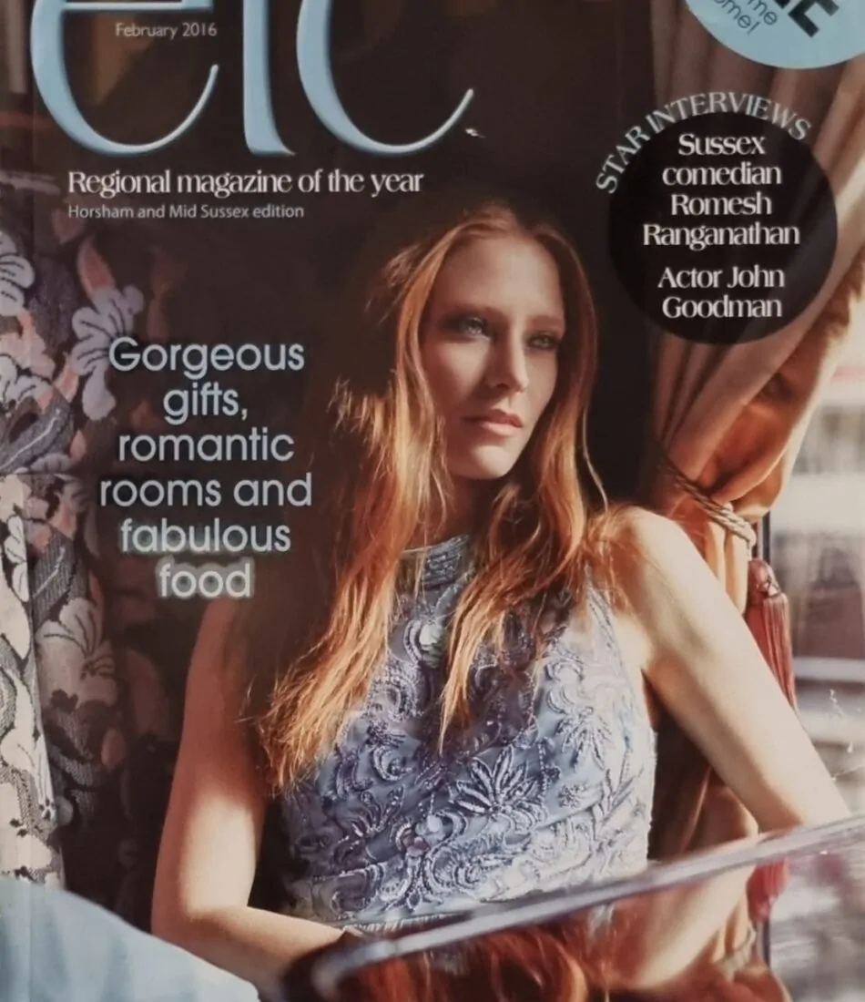 A fashion magazine cover features a young woman with long hair, wearing a stylish dress, sitting elegantly near a window. Text highlights themes of gifts, rooms, and food.