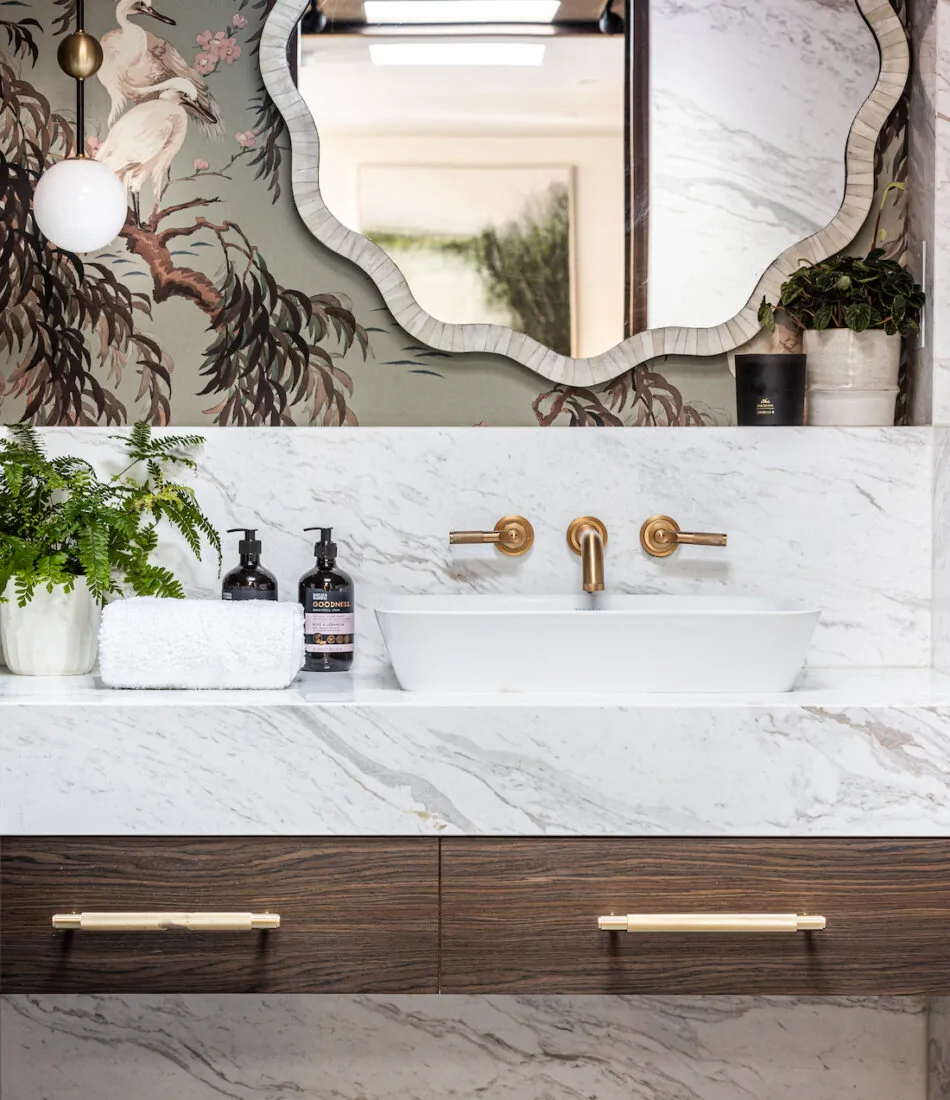 Pfeiffer Design bathroom oak drawers and marble sink with scenic wallpaper and gold hardware