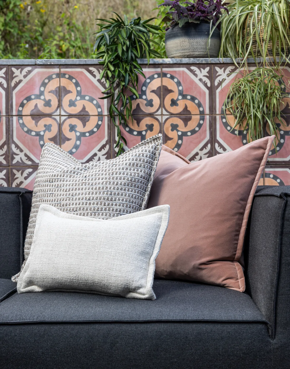 exterior furniture and cushions in pinks and greys with pink patterned wall tiles