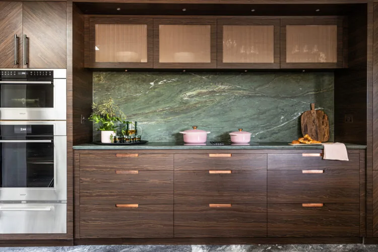Kitchen with dark oak cabinets, green marble worktop and back splash