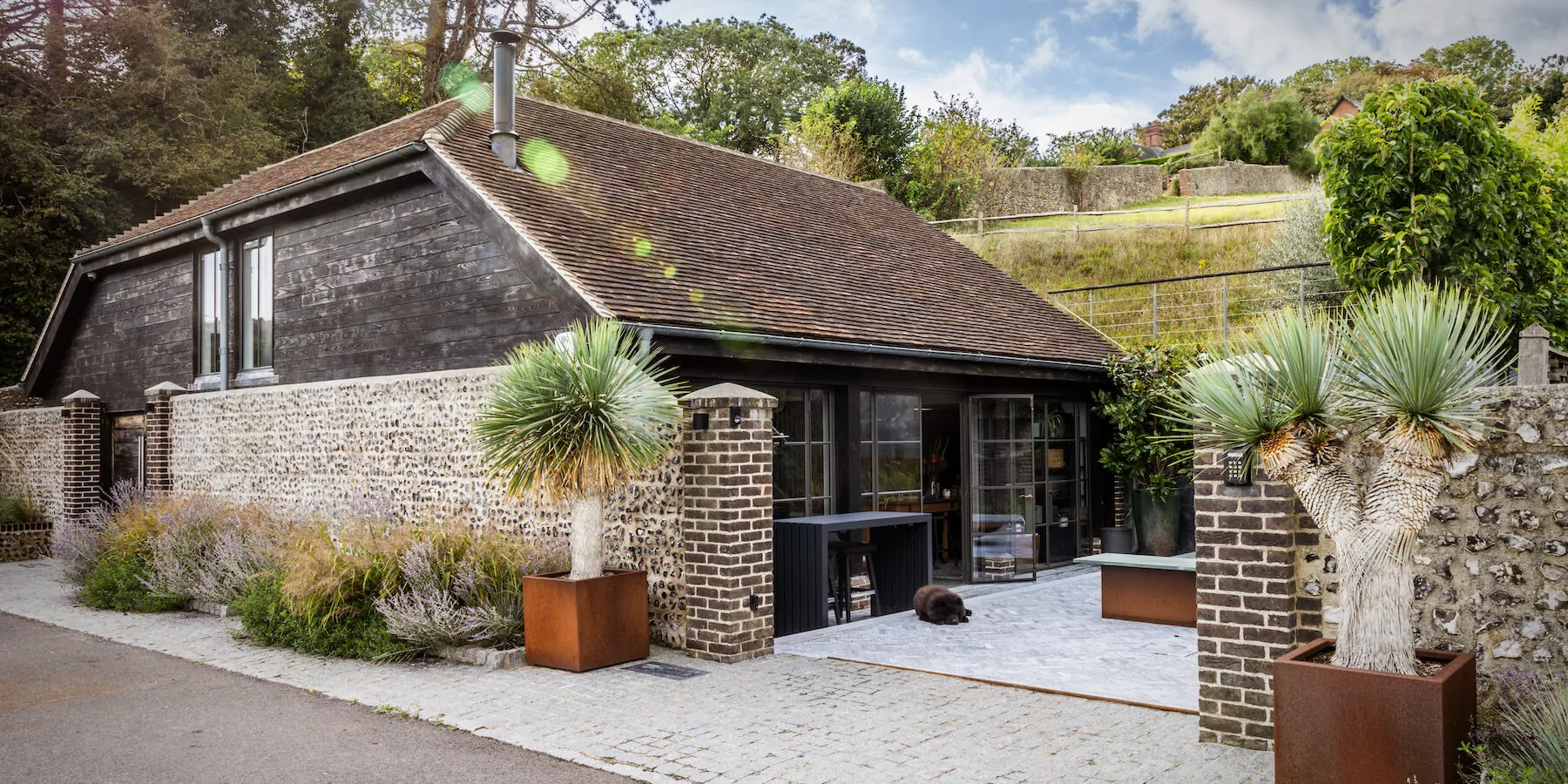 Exterior image of Pfeiffer design studio showing green landscape and brick wall