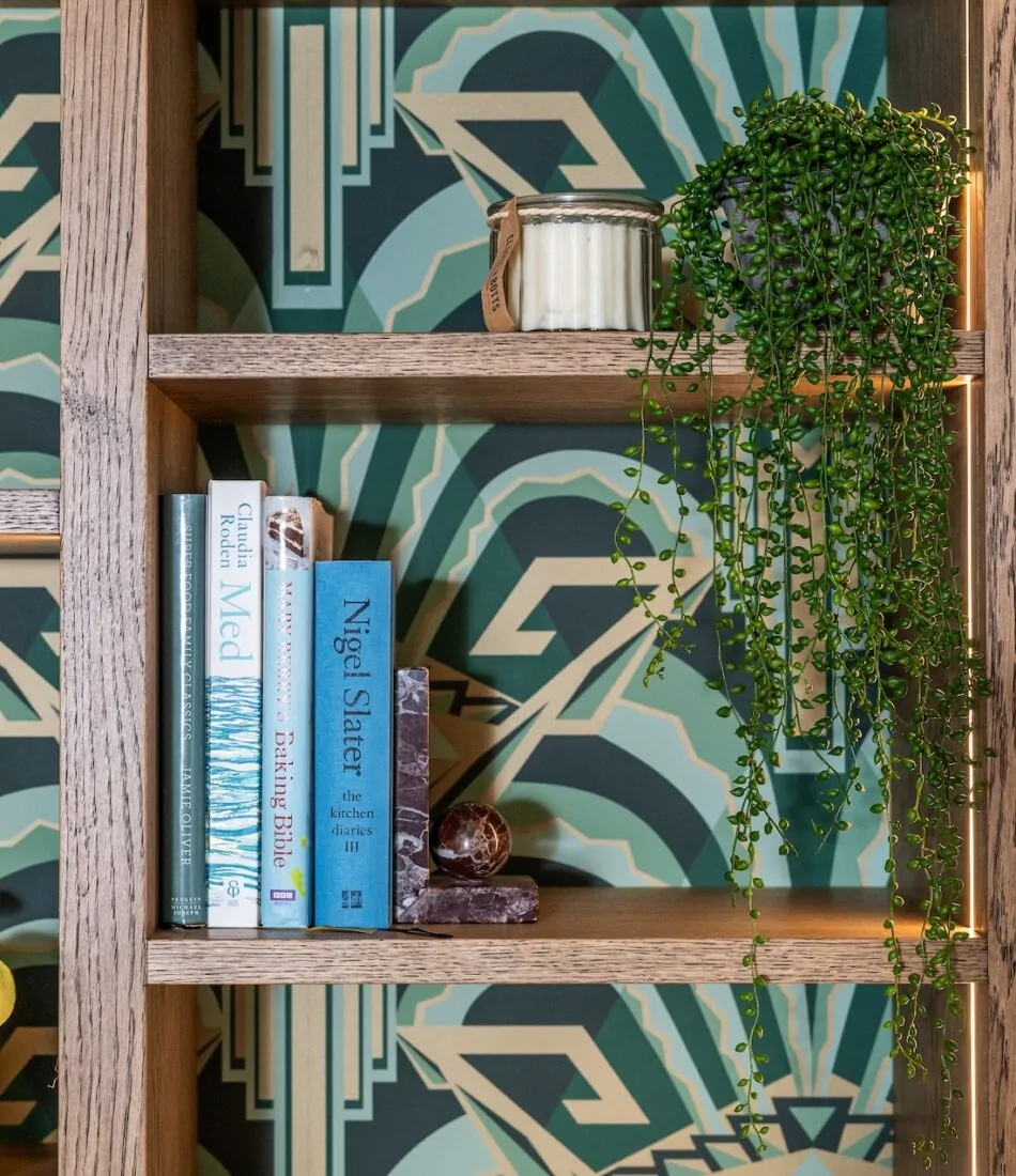 Art Deco Inspired Bespoke Bar and Library made by our bespoke joiners, designed by Pfeiffer Design. Art deco wallpapered insert within light timber open cabinetry, hints of gold through the backing and handles, and LED lighting for a warm but subtle glow
