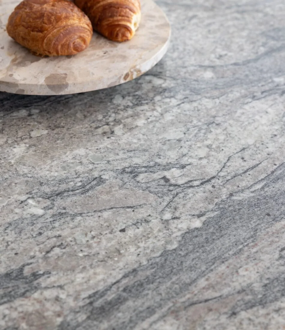 Art Deco Inspired Bespoke Kitchen made by our bespoke joiners, designed by Pfeiffer Design. Bespoke joinery, stone island work surface close up with breakfast pastries on a marble turntable platter