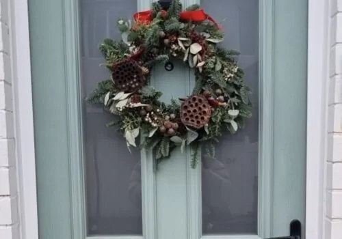 Festive wreath hanging on a blue door
