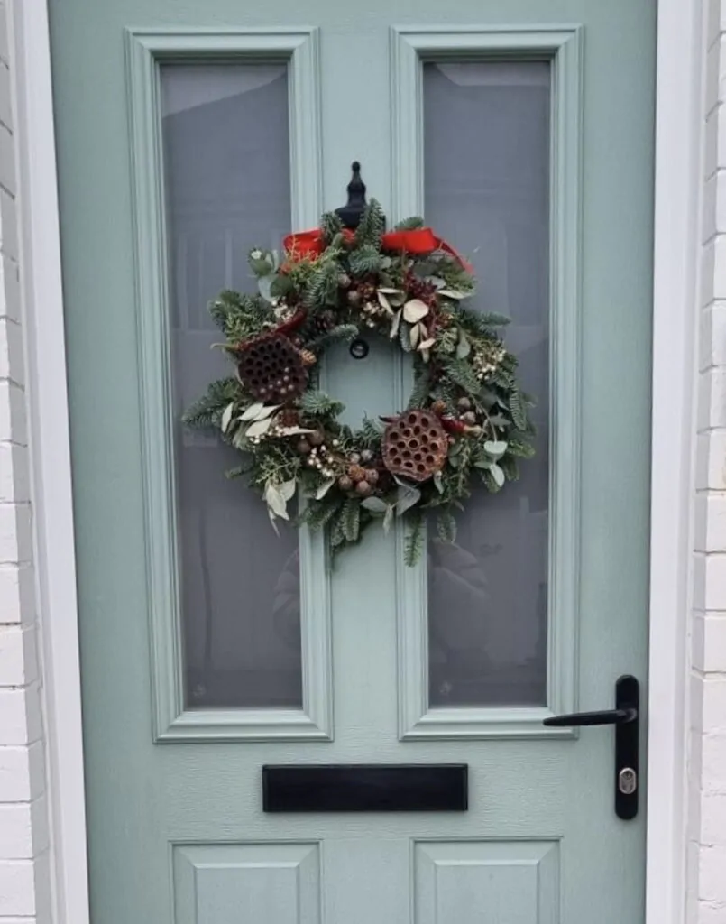 Festive wreath hanging on a blue door
