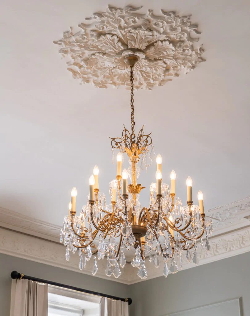 Close up image of traditional ceiling rose and original glass chandelier