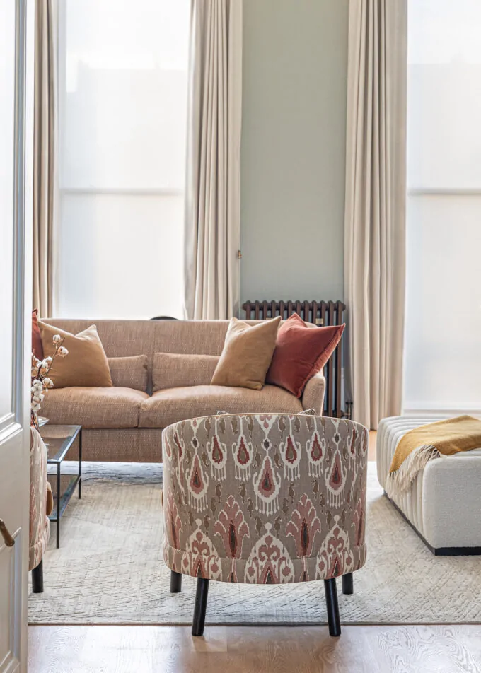Regency Townhouse Lounge Living Room Interior Design with focus on upholstered furniture arm chair with red, beige, warm patterns and yellow cushions